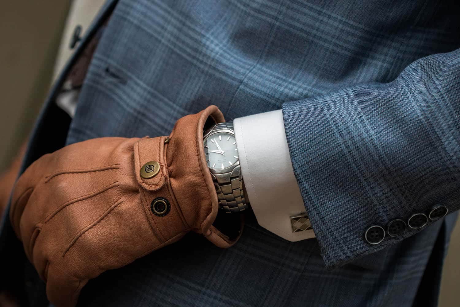 Man in pak met manchetknopen en horloge